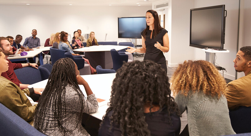 Photo of a speaker in front of an audience