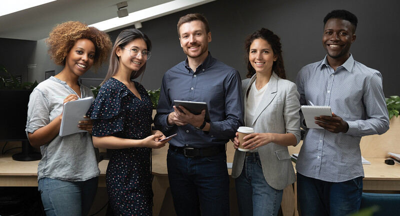 Photo of 5 young teachers standing in front of a blackboard.