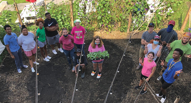 Project S.O.W. participants work on planting a garden.