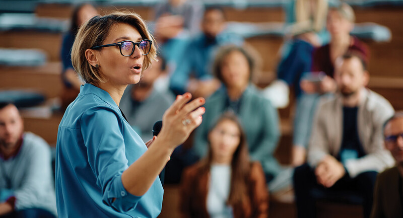 A school leader speaking to a gym full of teachers.