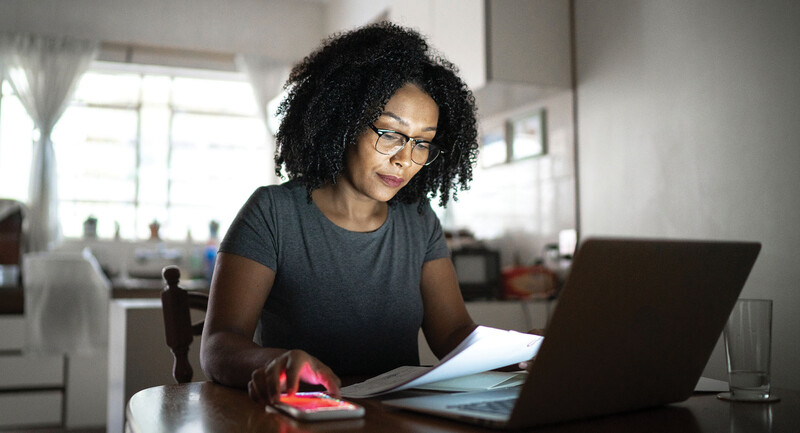 Woman engaged in planning work on laptop. 